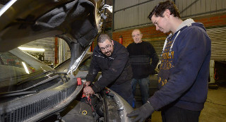 Sous le capot, Loïc Gayrard, mécanicien du garage solidaire du Ségala, et son père Didier, assistés de leur stagiaire Dylan Puech./Photo DDM, M.-P. Volle. 