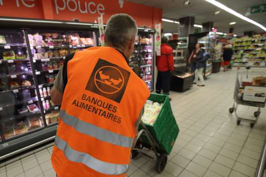 Un bénévole  des banques  alimentaires  récolte les dons  dans un  supermarché à  L’Haÿ-les-Roses  (Val-de-Marne)  le  26 mai 2015.  PHILIP PE WOJAZER/REUTERS